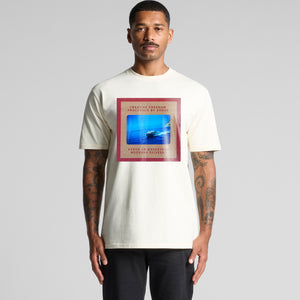 Man wearing a white t-shirt with a graphic design on a gray background