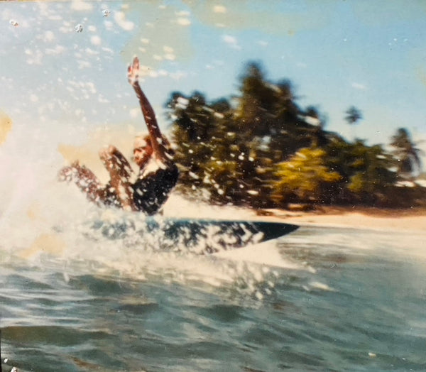 Person wakeboarding on a body of water with trees in the background