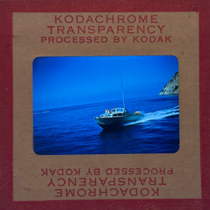 Kodachrome transparency with a boat on water and mountain in the background