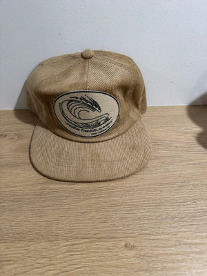 Beige cap with a logo on a wooden surface