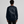 Person wearing a black sweatshirt with a white graphic design on the back against a gray background