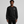Person wearing a black sweatshirt with a logo on a gray background