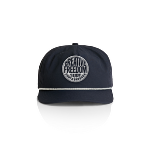 Navy blue cap with 'Creative Freedom Surf Santa Barbara' logo on a white background