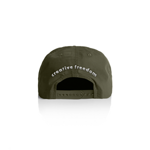 Green cap with 'creative freedom' text on a white background