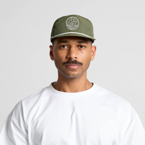 Man wearing a green cap with text on a plain background