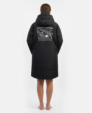 Person wearing a black coat with text and graphics on the back against a white background