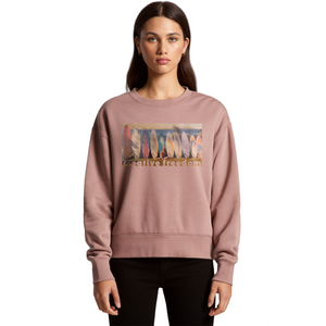 Person wearing a pink sweatshirt with a graphic design on a white background